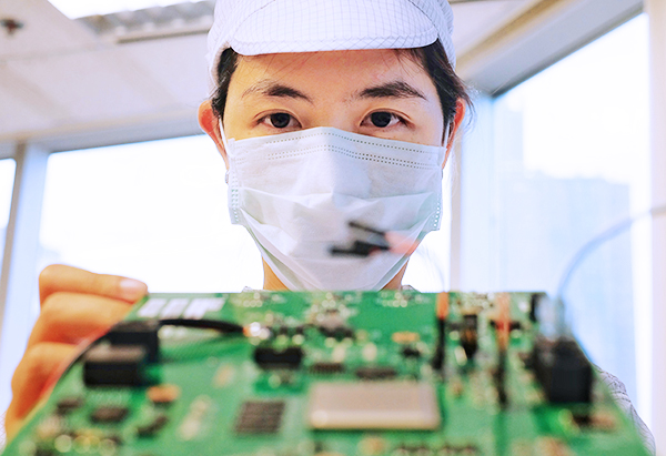 a man coating a printed circuit board with waterproof coatings