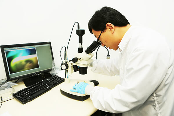 a coating engineer looking at parylene under a microscope